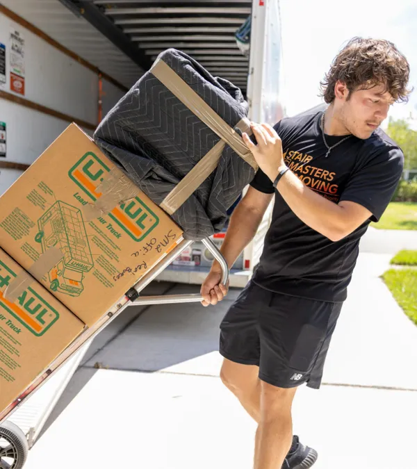 Stair Masters Moving crew member using a hand truck to load boxes into the moving truck in Jacksonville, FL